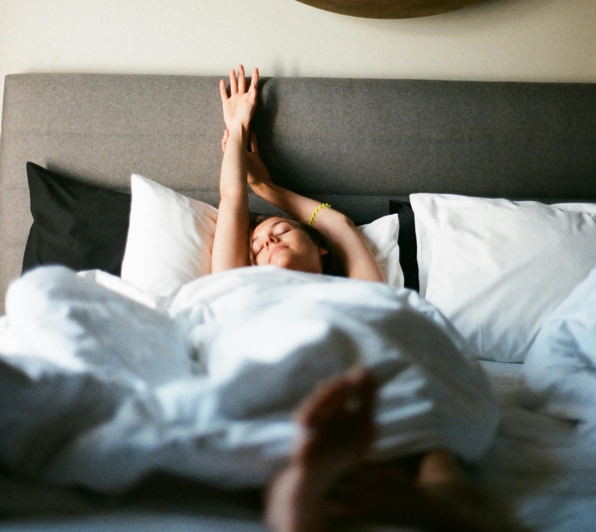 Lady stretching as she wakes in bed