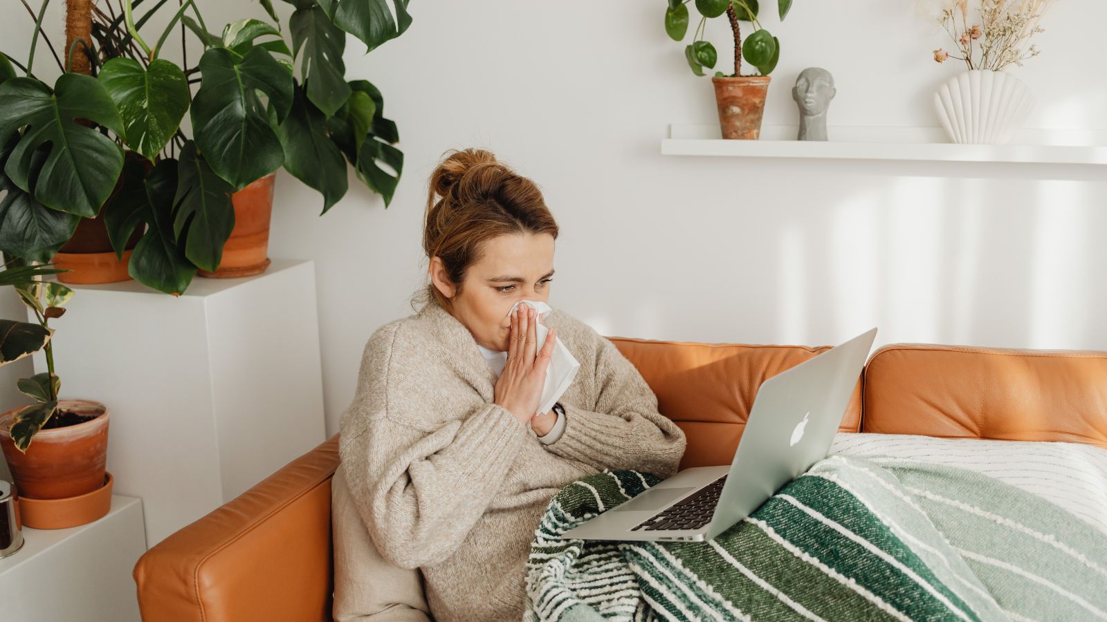 Woman working on the couch whilst sick