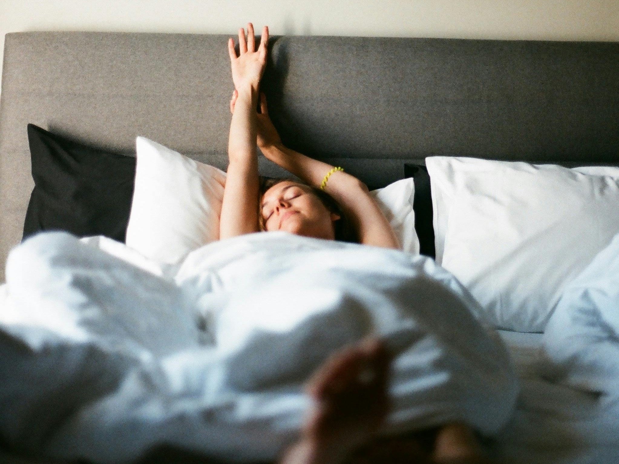 Lady stretching as she wakes in bed