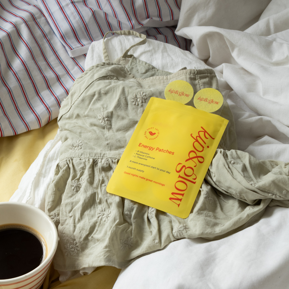 Yellow package of kip&glow Energy Patches on a light green shirt with a cup of coffee nearby.