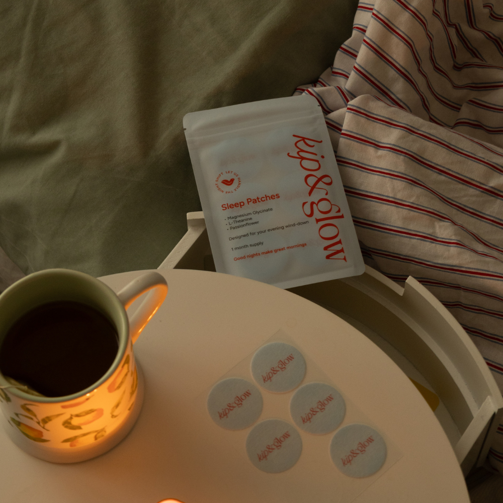 Pack of kip&glow sleep patches on a nightstand with a mug and candle